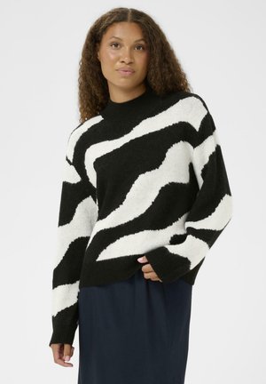 Gestreifter Pullover in Schwarz und Weiß mit hohem Hals und langen Ärmeln, der eine weiche, flauschige Textur aufweist. Die Streifen haben ein wellenförmiges Muster.