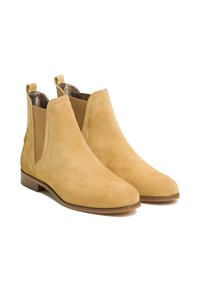 Bottines en daim beige clair avec panneaux latéraux élastiques et petit talon empilé. Doublure intérieure lisse et accents de design minimalistes.