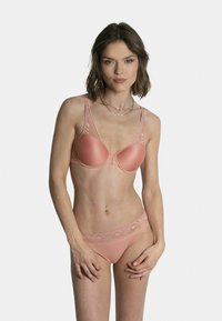 Ensemble de lingerie rose pâle comprenant un soutien-gorge rembourré avec des accents en dentelle et un slip assorti bordé de dentelle. Texture lisse et design ajusté.