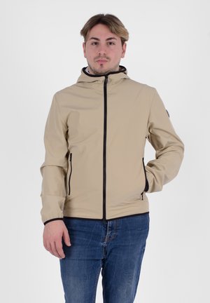 Giacca zip-up beige con cappuccio, dotata di dettagli neri sulla zip e tasche laterali, realizzata in materiale liscio e leggero.