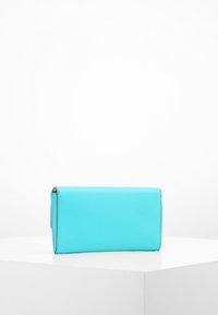 Jasnoniebieski portfel o gładkiej fakturze, prostokątnym kształcie i z zamkiem błyskawicznym. Prosty design bez widocznych elementów metalowych ani akcentów.