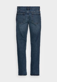 Jean en denim bleu foncé avec une coupe droite, cinq poches et des coutures contrastées. À l'arrière, deux poches plaquées avec un minimum de détails.