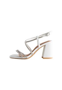 Sandal con tacco blocco bianco, con cinturini decorati da rhinestone trasparenti, materiale liscio e chiusura con fibbia.