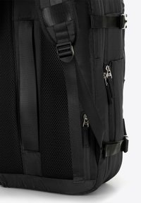 Zaino nero con pannelli laterali in rete, multiple tasche con cerniera, spallacci regolabili e tessuto resistente. Presenta superfici lisce e texturizzate.