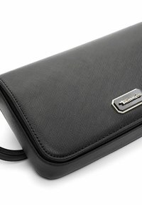 Zwarte textuur portemonnee met een rechthoekige vorm, voorzien van een zilverkleurig merkembleem en een soepele ritssluiting. Gemaakt van synthetisch materiaal.