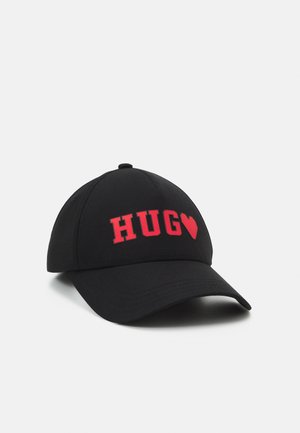 Sort baseballkasket med rød tekst "HUG" og et rødt hjerte foran, vist på hvid baggrund.