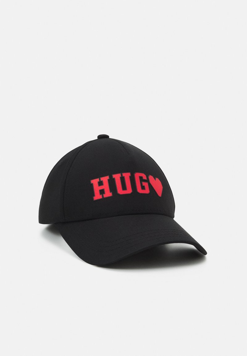 Casquette de baseball noire avec texte rouge "HUG" et un symbole de cœur rouge à l'avant, affichée sur fond blanc.