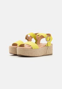 Sandalias de plataforma de ante amarillo con tiras cruzadas y hebilla redonda, suela de esparto texturizada y plantilla acolchada.