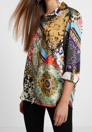 Wielobarwna jedwabna koszula z różnymi wzorami, w tym zwierzęcymi nadrukami i ozdobnymi motywami, o luźnym kroju i podwiniętych rękawach.