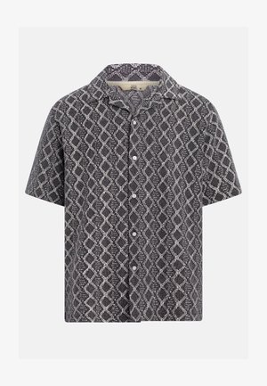 Chemise à manches courtes avec boutons, motif géométrique losange noir et blanc, col évasé, taille moyenne.