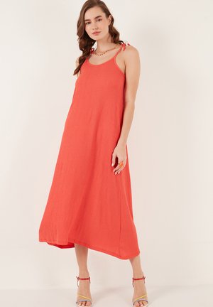 Largo vestido coral sin mangas hecho de tejido texturizado. Cuenta con delgadas tirantes con lazos, un diseño fluido y un corte hasta los tobillos.