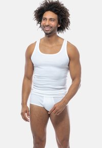White cotton tank top with wide straps, paired with white briefs. Smooth texture, fitted design, and no additional patterns or accents.