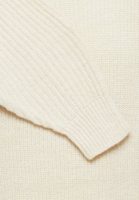 Ribbet striktrøje i off-white. Har en tekstureret overflade med lange ærmer og tætsiddende manchetter. Blødt materiale, minimalistisk design.