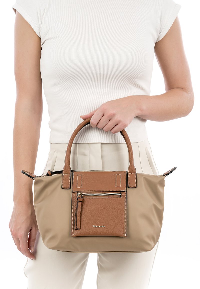 Bolso sintético de color marrón claro con detalles en cuero marrón, asas dobles, bolsillo con cremallera y costuras decorativas. Textura suave, forma rectangular compacta.