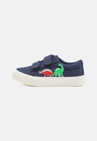 Baskets en toile navy avec semelle en caoutchouc blanche, ornées de broderies de dinosaures rouges et verts sur le côté extérieur et de bandes Velcro pour la fermeture.