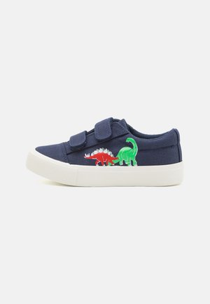 Navyblaue Leinensneaker mit weißer Gummisohle, auf der Außenseite mit roten und grünen Dinosaurier-Stickereien sowie Klettverschlüssen zum Schließen.