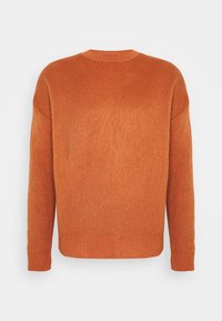 Pomarańczowy sweter dziany z okrągłym dekoltem, opuszczonymi ramionami oraz ściągaczami na rękawach i dole. Teksturowana tkanina o miękkim wyglądzie.