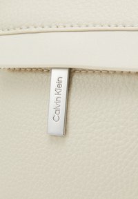 Calvin Klein MUST CAMERA BAG UNISEX - Keresztpántos táska - dark ecru