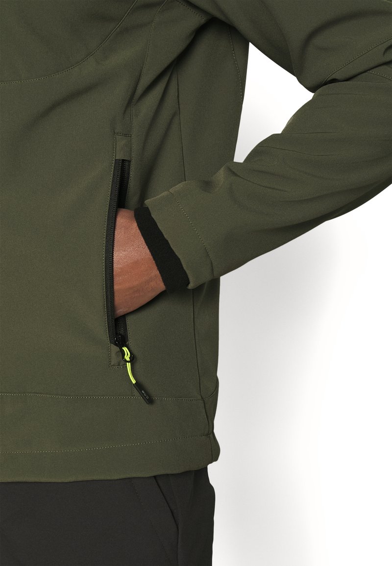 Chaqueta verde oliva con una textura suave, que presenta un bolsillo con cremallera, puños negros y un acento amarillo brillante en la tira de la cremallera.