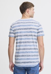 Lys grå stribet T-shirt med vandrette blå striber i forskellige bredder. Korte ærmer og en rund kant.