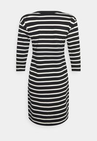 Černobíle pruhované šaty s 3/4 rukávy, přiléhavý střih, kulatý výstřih a délka po kolena. Hladká látka s klasickým vzorem.