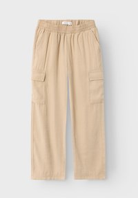 Beige cargobyxor med elastisk midja, sidofickor och två cargofickor. Tyget verkar mjukt med en slät textur.