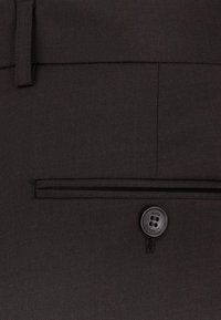 Czarne materiałowe spodnie z płaskim przodem, z boczną kieszenią i pojedynczym czarnym guzikiem. Gładka tekstura z dopasowanym krojem.