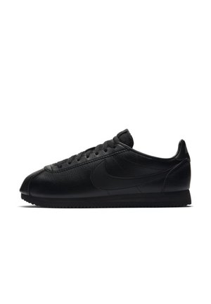 Czarny skórzany niski sneaker z czarnymi sznurowadłami i czarnym logo Nike Swoosh po boku, przedstawiony na białym tle.