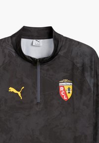 Zwarte sporttop met een half-rits kraag, voorzien van het logo van Racing Club de Lens in rood, geel en zwart, naast een geel Puma-logo.