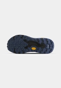 Semelle extérieure Vibram d'une chaussure avec une surface en caoutchouc bleu texturé, comportant des crampons multidirectionnels pour l'adhérence et une semelle intermédiaire noire pour le soutien.