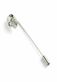 Hopeakahva turvallisuusneula, jossa on pääkallomuotoinen korkki. Pääkallolla on ontot silmät ja yksityiskohtainen leuka, sekä sileä, pitkulainen neula.