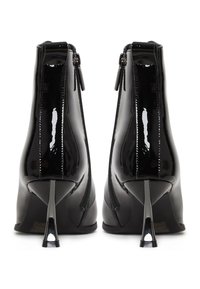 Černé lakované kotníkové boty s lesklým povrchem, které mají elegantní design, zapínání na zip a jehlový podpatek se špičatým tvarem.