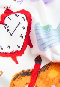 Tissu blanc avec des illustrations colorées ; une horloge rouge, un crayon marron et diverses formes abstraites en vert et violet. Surface texturée.