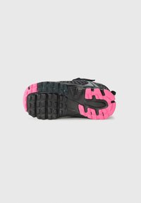 Sole di scarpa sportiva nera con un design testurizzato, caratterizzata da dettagli rosa e scanalature per la trazione, realizzata in materiale gommoso.
