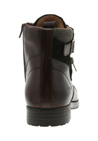 Bottine en cuir marron à finition lisse, avec un panneau en tissu texturé, une fermeture éclair latérale et un détail de boucle ajustable. Semelle en caoutchouc durable.