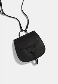 Bolso bandolera de cuero negro texturizado con una tapa curva, detalle de anillo de metal y correas ajustables. Presenta un cierre de cordón.