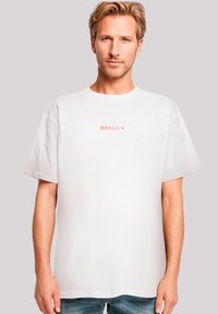Witte katoen t-shirt met korte mouwen en een ronde hals. Bevat rode Japanse tekst op de voorkant. Casual pasvorm en een gladde textuur.