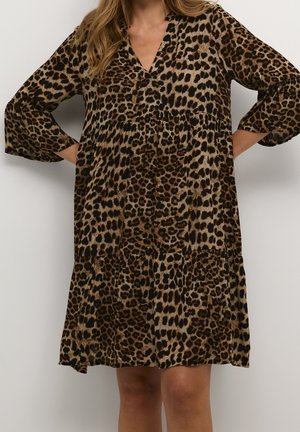 Løs kjole til knæet med lange ærmer og et brunt og sort leopardmønster.