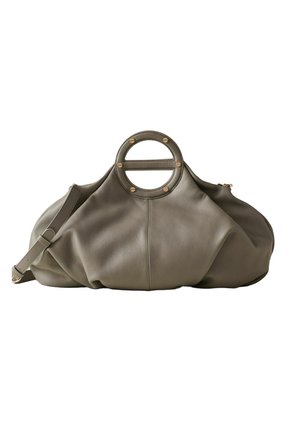 Weiche graue Lederhandtasche mit einem einzigartigen runden oberen Griff, befestigt mit goldfarbenen Nieten und einem verstellbaren Schulterriemen.