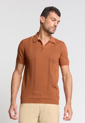 Braun gestricktes Polohemd mit kurzen Ärmeln, das eine strukturierte Textur und einen gerippten Saum aufweist. Rote Knöpfe zieren den Kragen für einen zusätzlichen Akzent.