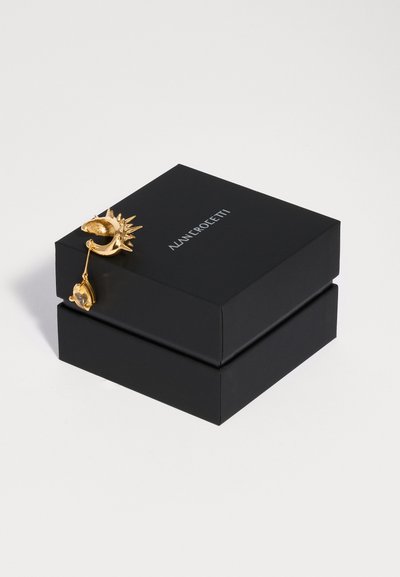 Orecchino d'oro a forma di sole e luna con cristallo pendente su scatola per gioielli nera NANNI ROLOETTI su sfondo bianco.