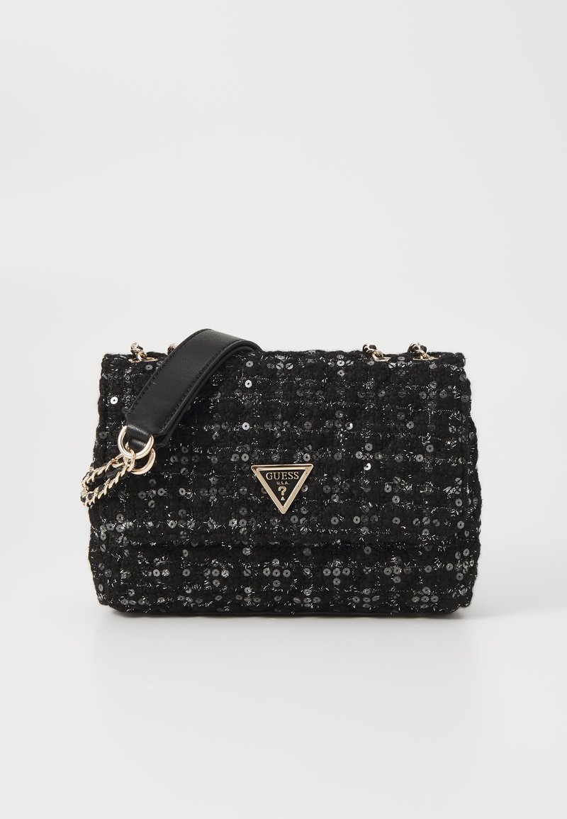 Czarna torebka z cekinami o pikowanym wzorze, złotym trójkątnym logo oraz łańcuszkiem i paskiem ze skóry. Posiada klapę zapinaną na zatrzask.