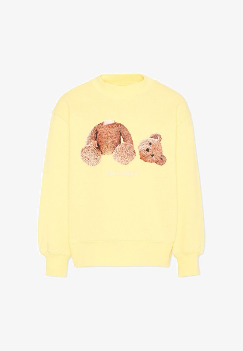 Geel sweatshirt met een afbeelding van een bruine teddybeer waarvan het hoofd en het lichaam op de voorkant gescheiden zijn.