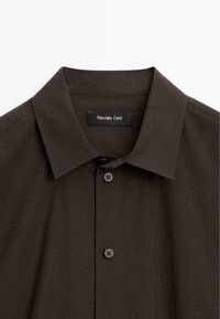 Camicia button-up marrone scuro con colletto strutturato, caratterizzata da un design semplice, sei bottoni e un'etichetta interna che recita "Massimo Dutti."