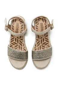 Sandalias beige con una superficie texturizada, que presentan una correa dorada brillante y un hebilla ajustable en el tobillo. Plantilla con estampado de hojas. Talla 31.