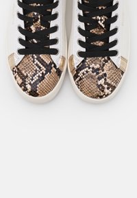 Sneaker basse con una toma in pelle bianca, lacci neri e un cappuccio in pitone marrone e oro testurizzato. Suola in gomma dalla forma arrotondata.