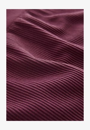 Puhasta, rebrasta tkanina v globokem burgundskem odtenku, s subtilno valovito teksturo. Mehka in fleksibilna materiala s doslednim vzorcem po celotni površini.