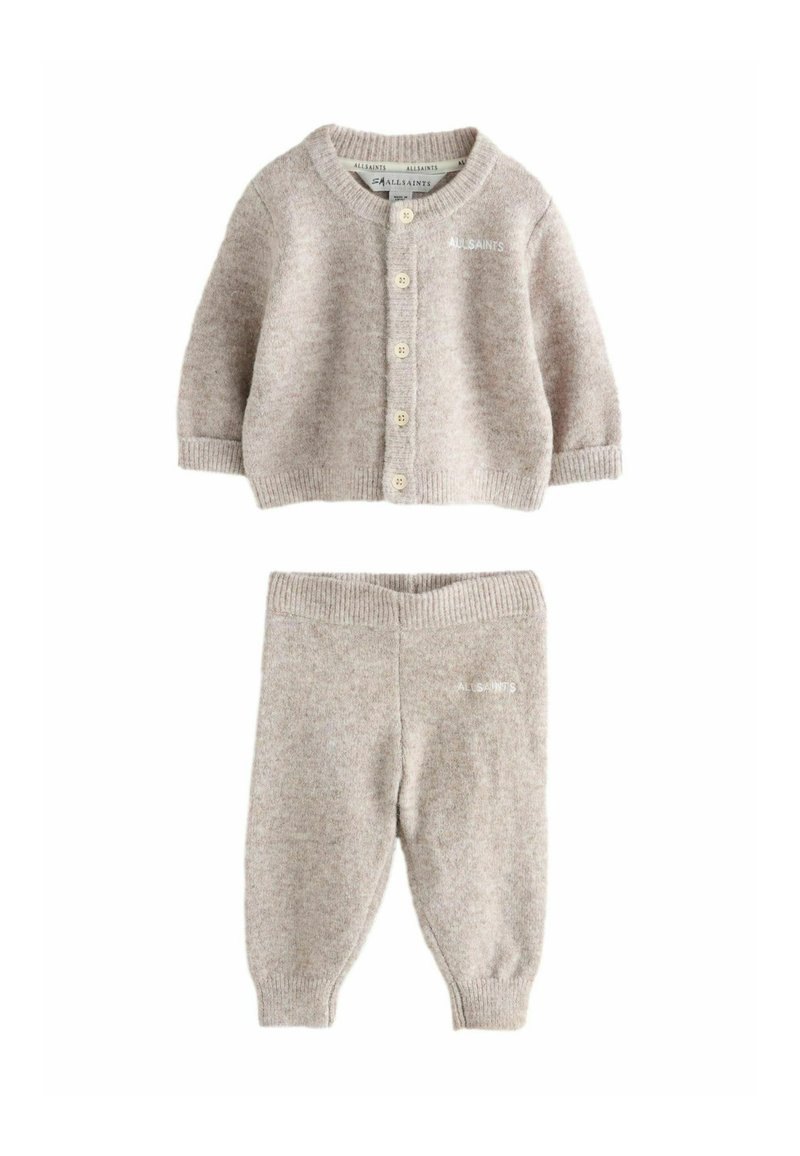 Conjunto de bebé de punto en color beige, que incluye un cárdigan abotonado y pantalones a juego. Presenta un cuello y cinturilla acanalados, con detalles de logotipo.