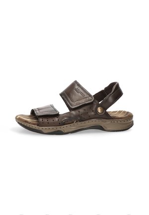 Sandalia marrón de cuero con puntera abierta, tiras de velcro ajustables, plantilla acolchada y detalles perforados en una suela beige texturizada.