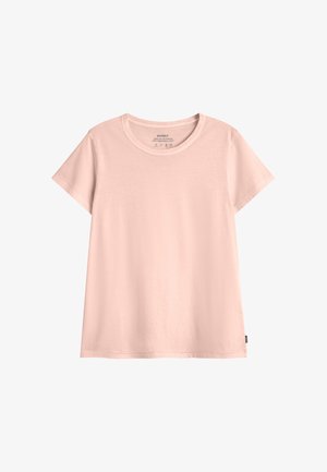 Jasnoróżowa bawełniana koszulka z krótkim rękawem, okrągłym dekoltem i małą czarną metką marki na dolnym bocznym szwie.